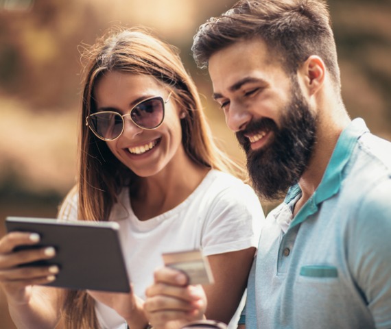 Man and women with sunglasses looking at tablet